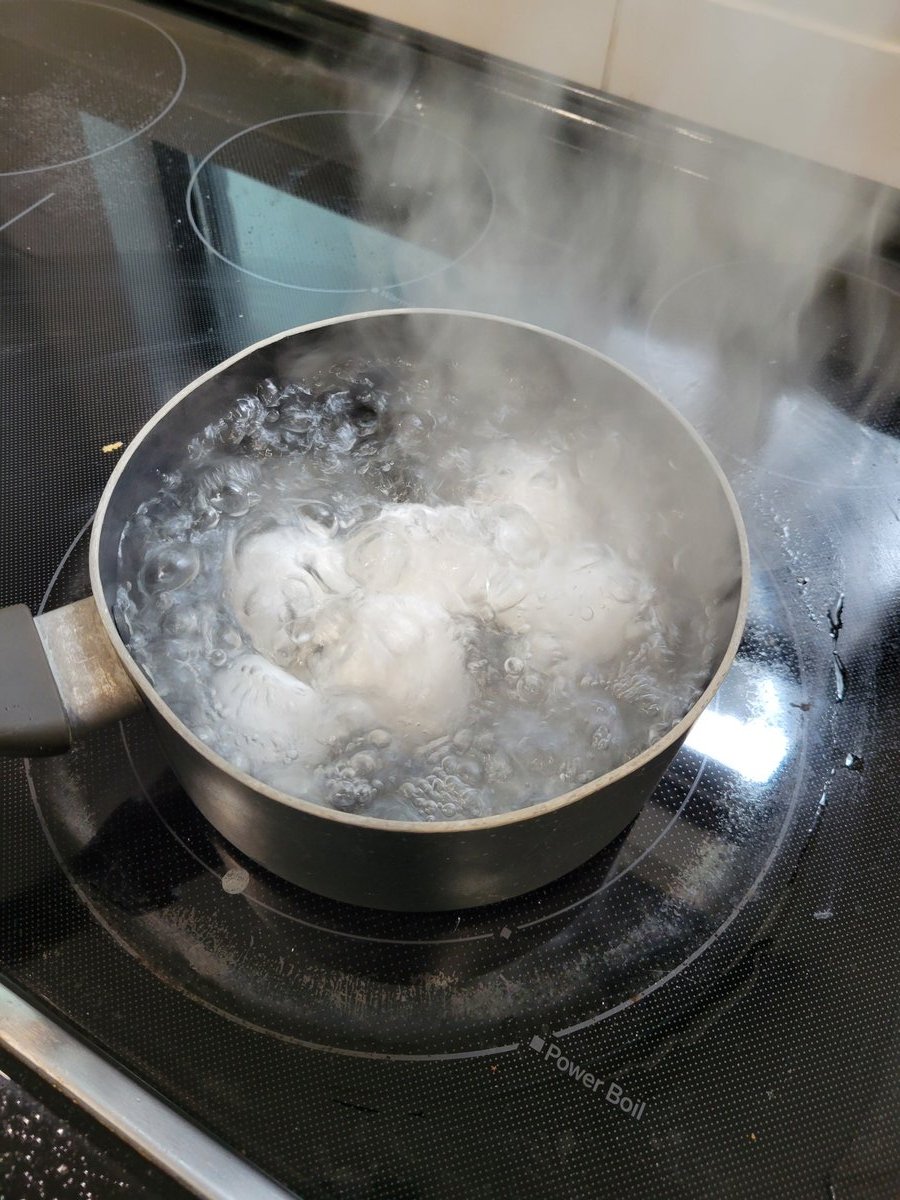Hard boiled eggs in a pot of vigorously boiling water with big bubbles