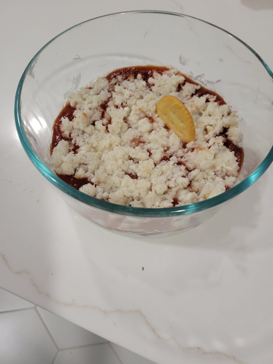Layered crab dip with cream cheese, cocktail sauce, and crab meat on a plate