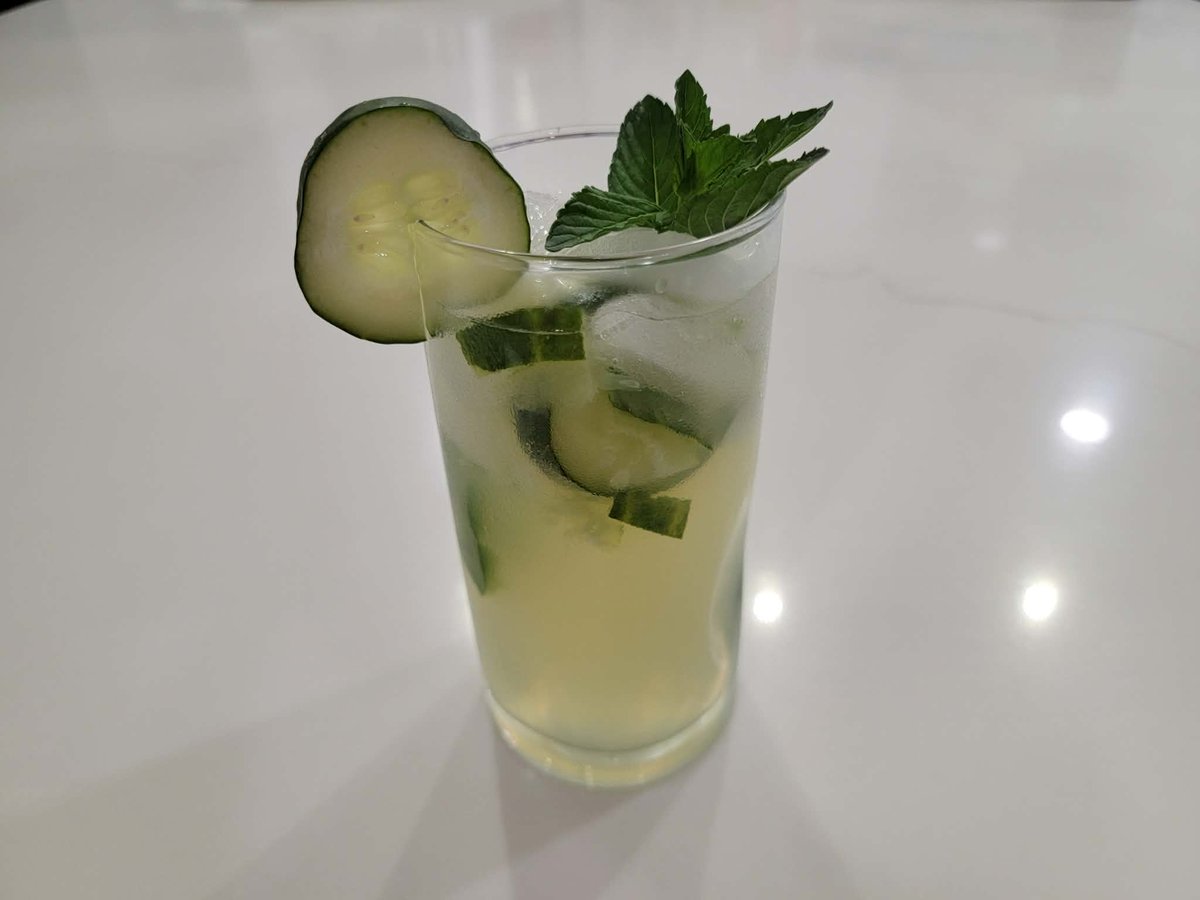 A cucumber jalapeño mojito garnished with cucumber spear and mint