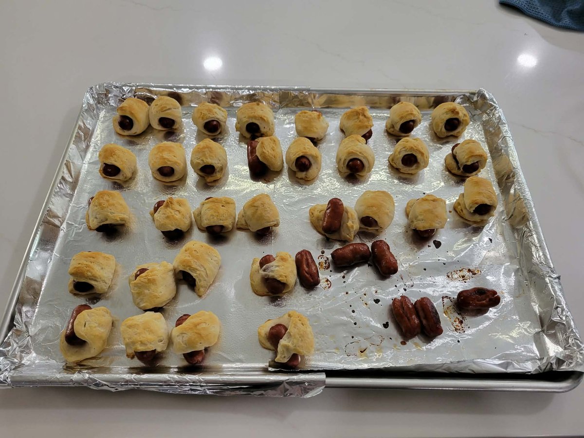A tray of golden-brown pigs in a blanket fresh from the oven