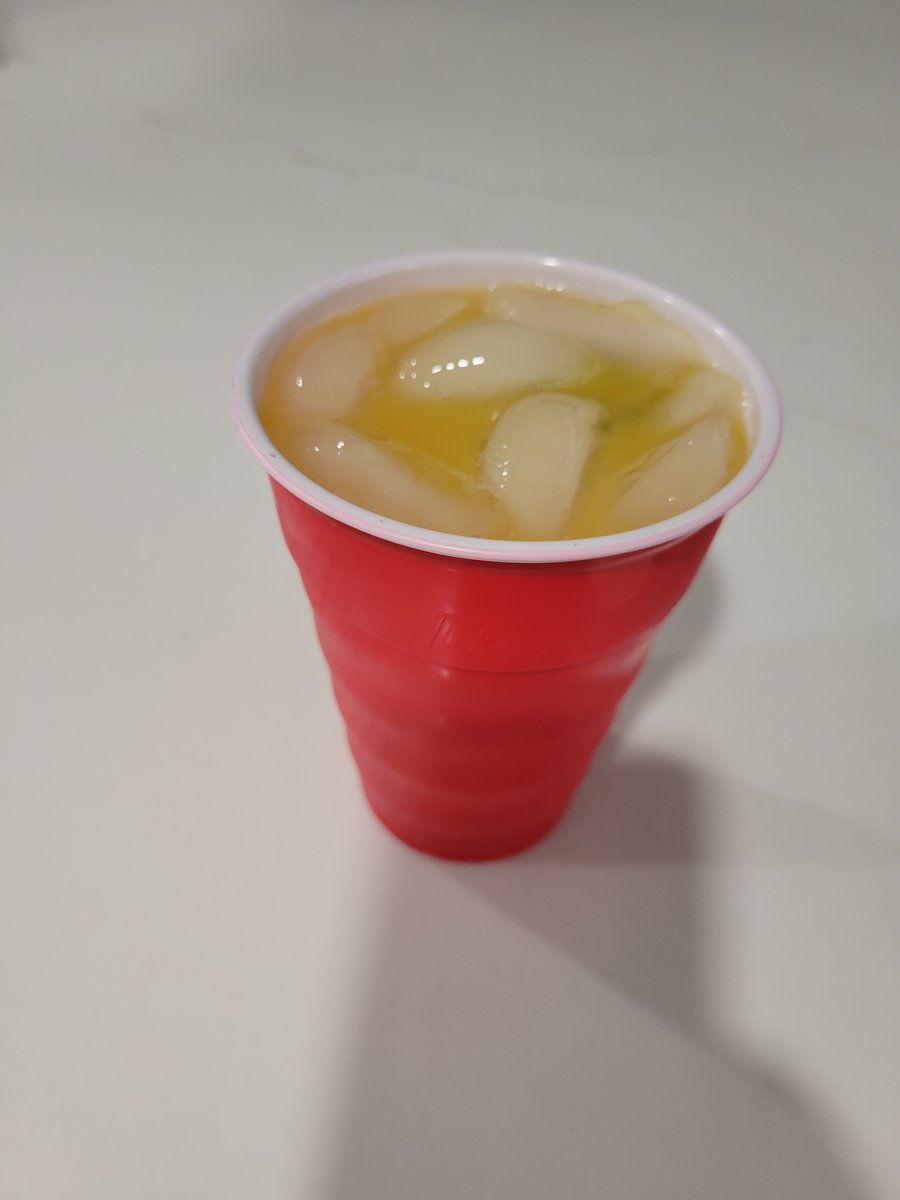 A mango jalapeño mojito in a glass with a jalapeño slice garnish